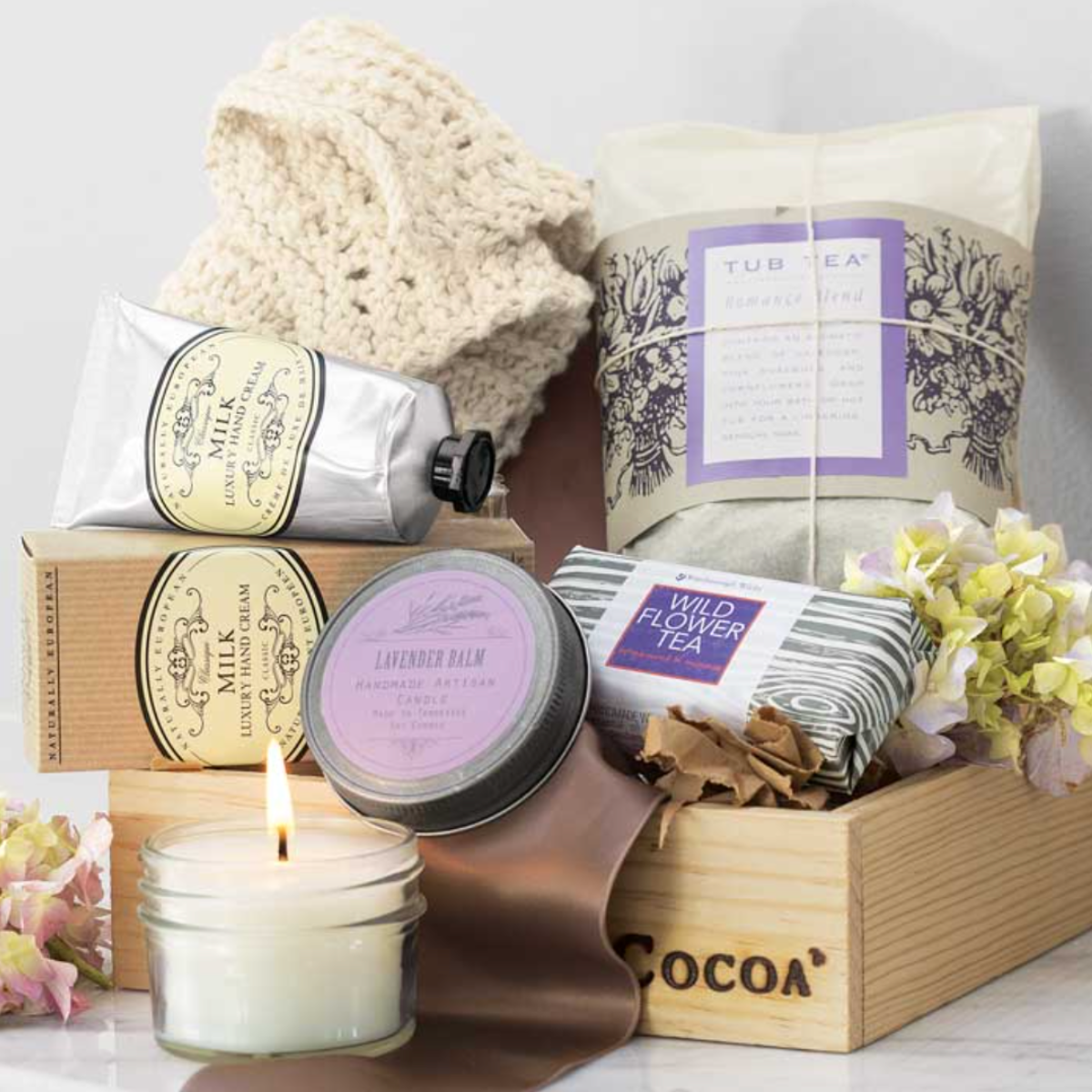 A Serenity Spa Crate gift set from Olive and Cocoa, featuring a candle, succulent, natural soap, and other bath accessories.